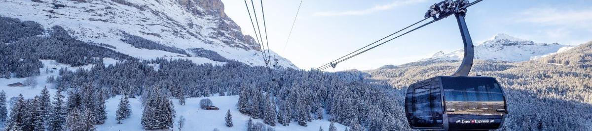 a gondola is going down a snowy mountain