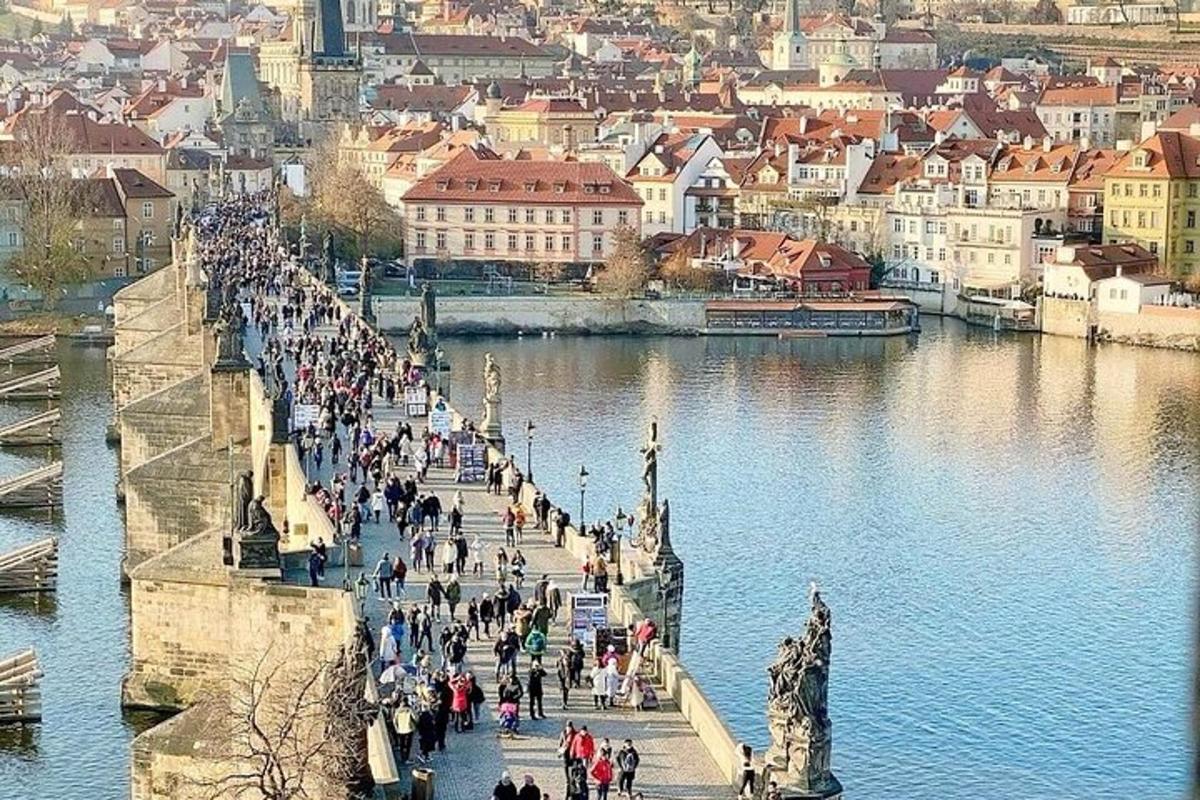 dav lidí jdoucích po mostě přes řeku