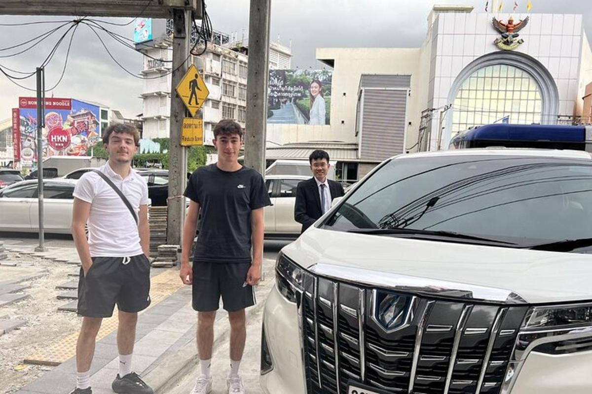 Tres jóvenes de pie junto a un coche blanco
