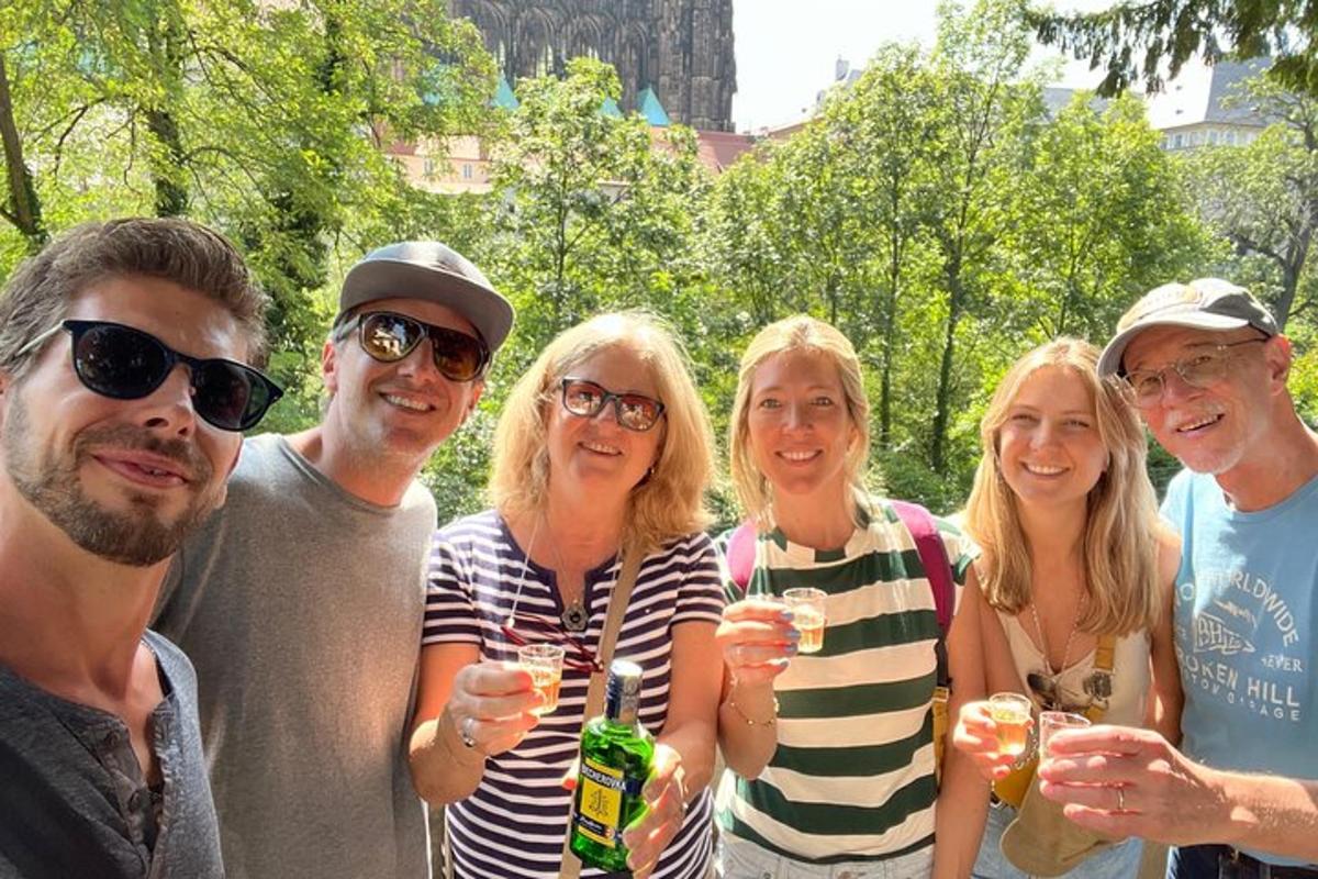 skupina lidí pózujících pro fotografii se sklenicemi na víno