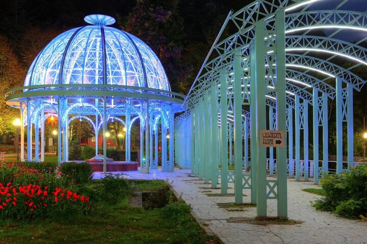 Egy kék kupolás pavilon a kertben éjszaka