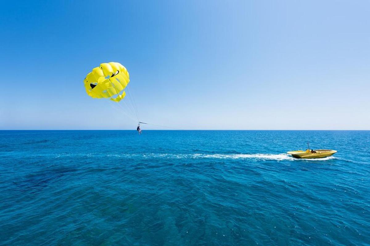 osoba pouštějící draka nad oceánem s lodí