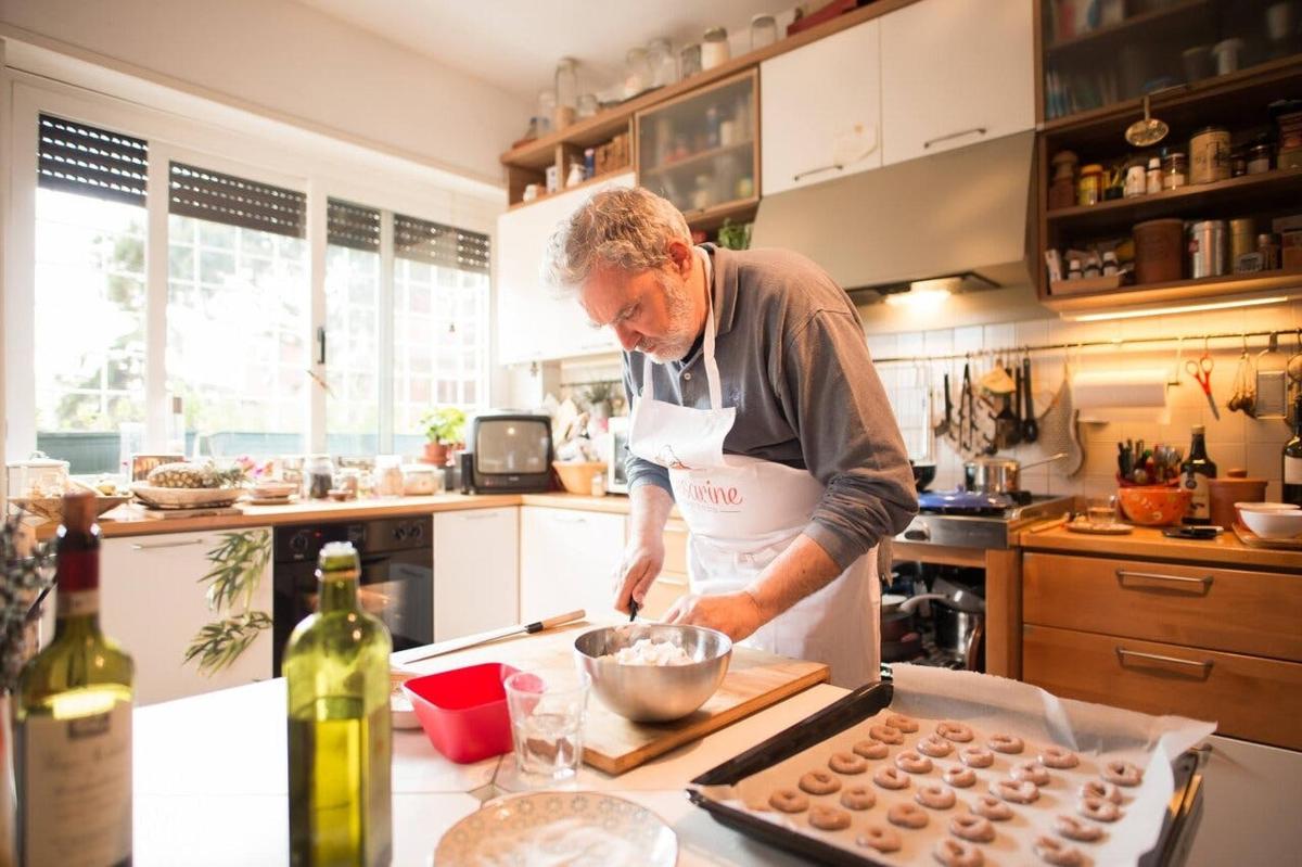 un uomo in piedi in una cucina che prepara dei cupcake