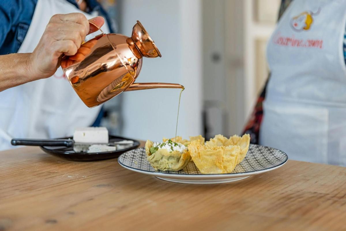 una persona que vierte comida en una olla sobre una mesa