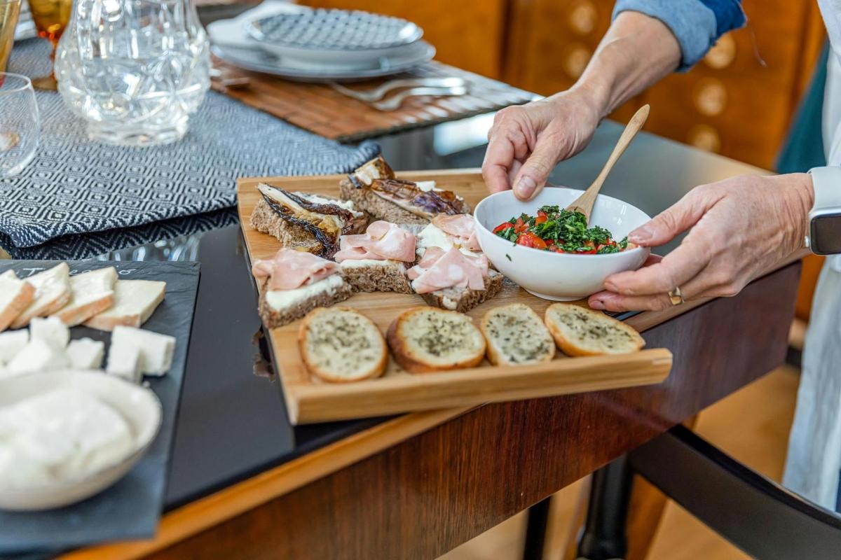 una persona que sostiene un tazón de comida en una tabla de cortar