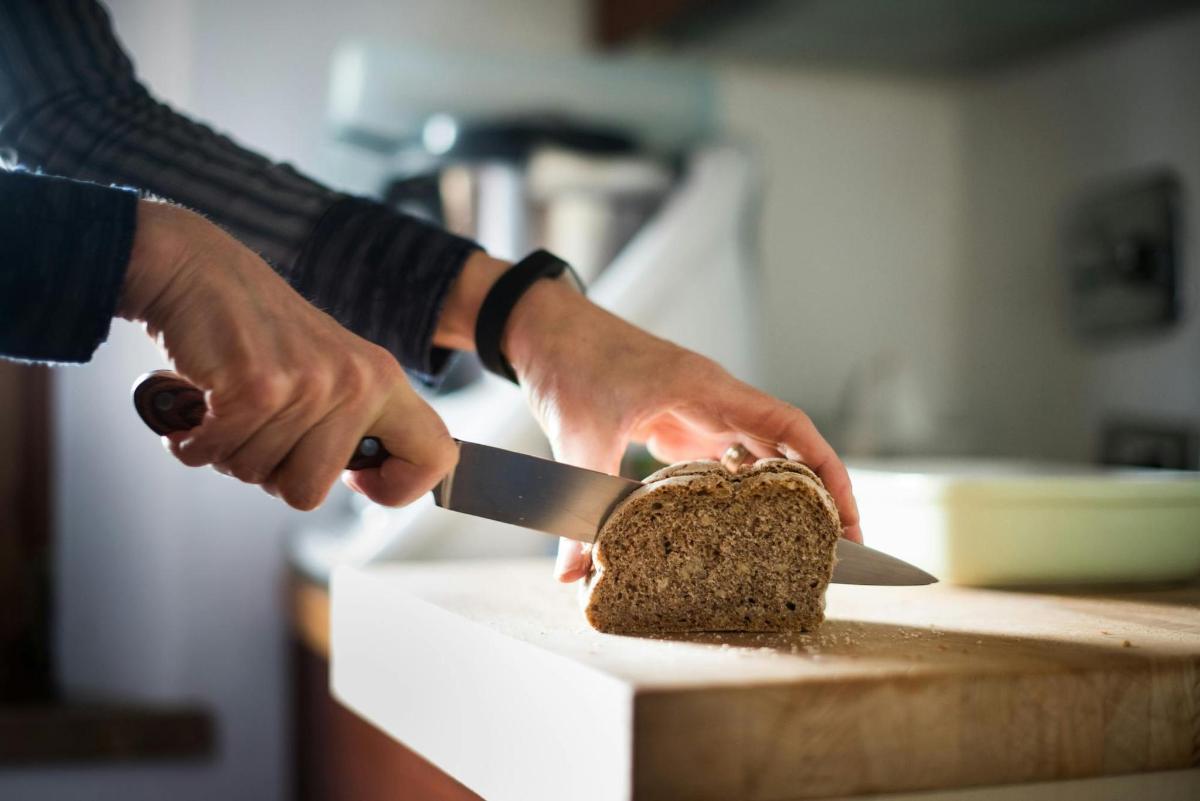 una persona che taglia una fetta di torta con un coltello