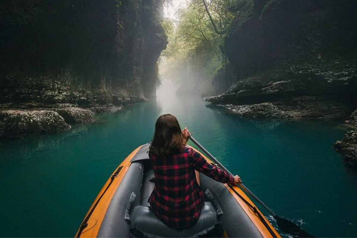 una donna sta remando su una barca lungo un fiume