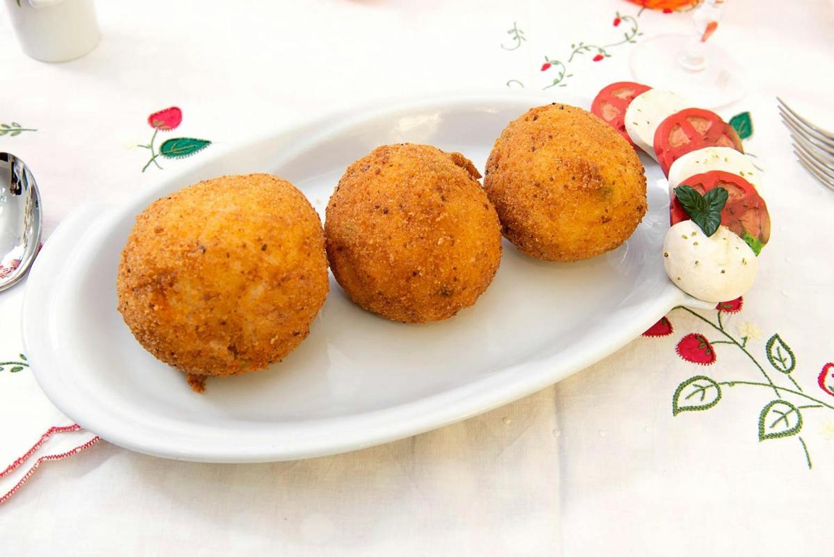 a white plate with four balls of food on a table