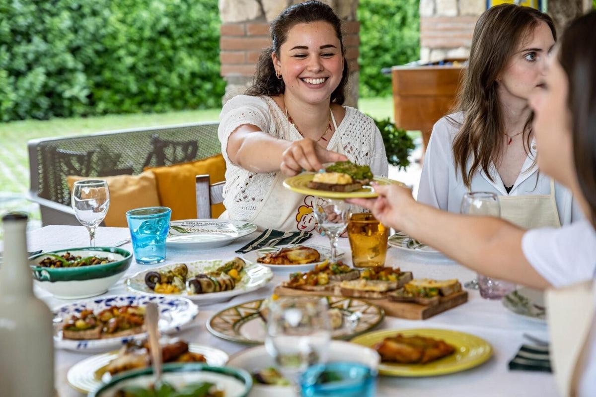 un gruppo di donne sedute a un tavolo che mangiano cibo