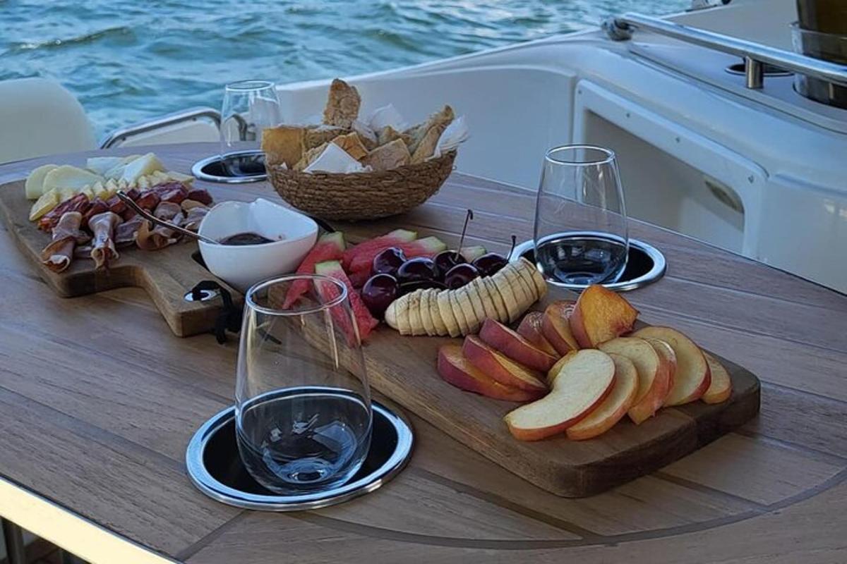 uma mesa com uma bandeja de comida e taças de vinho
