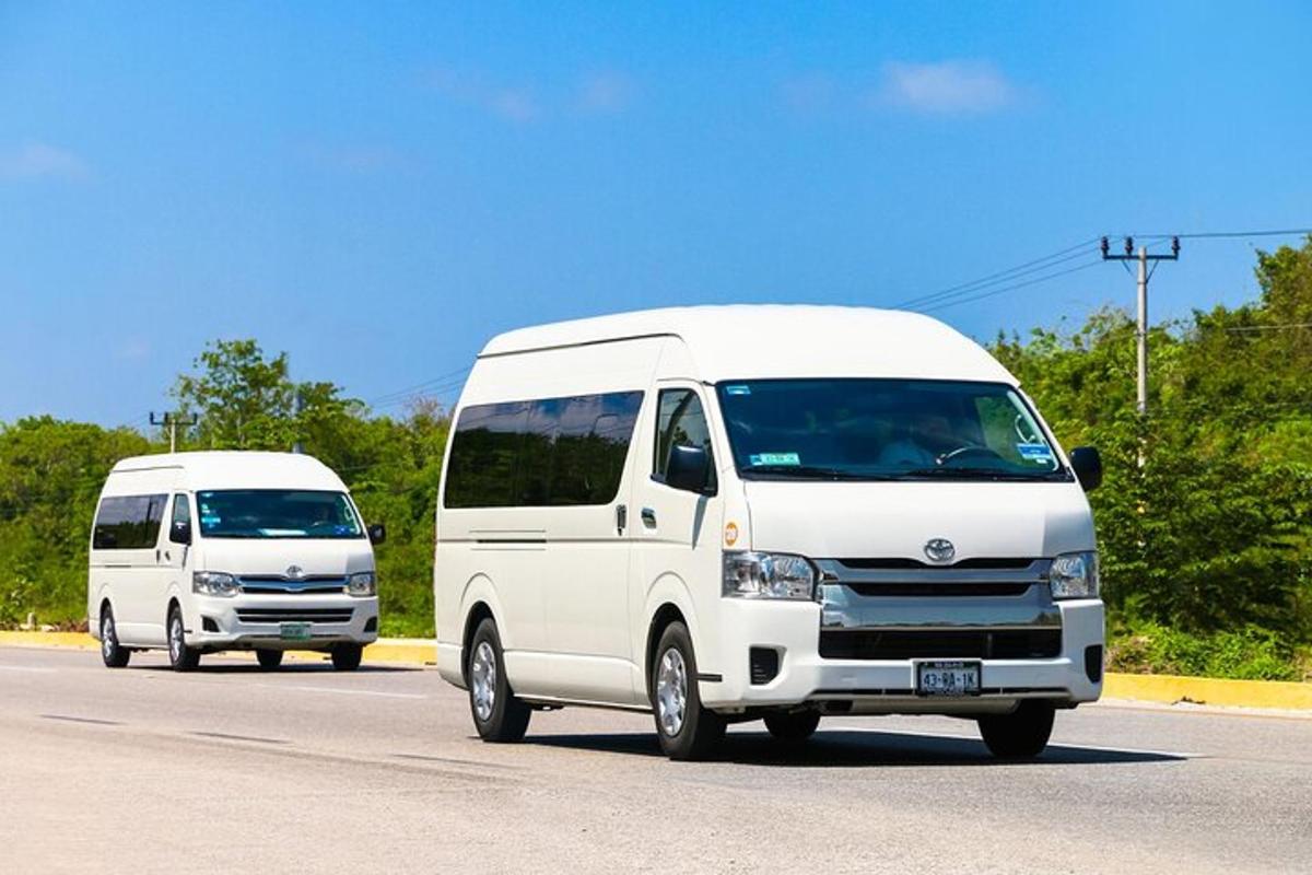 duas vans brancas estão dirigindo por uma estrada