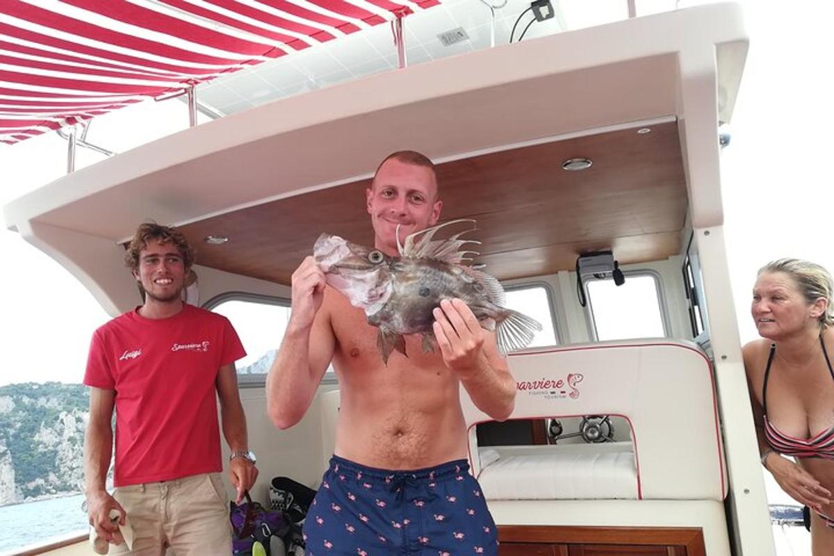 um homem segurando um peixe em um barco