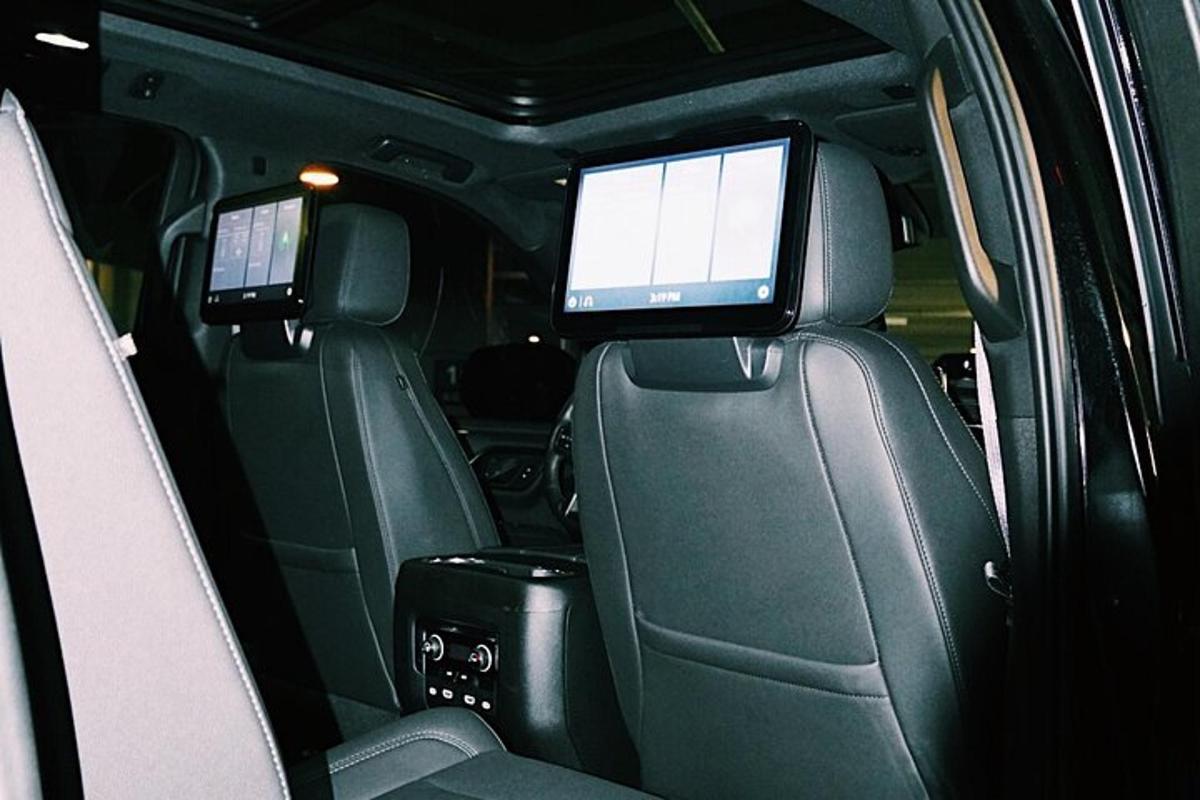 dos monitores en el asiento trasero de un coche