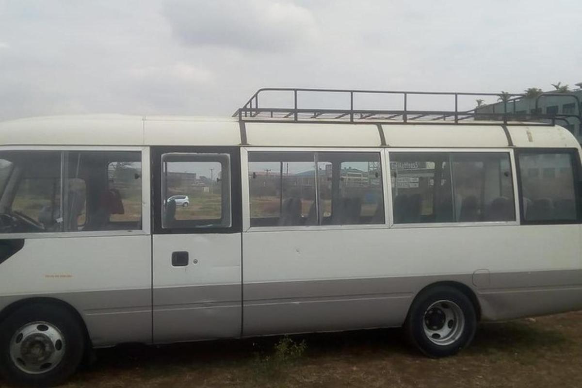 a white bus is parked in a field