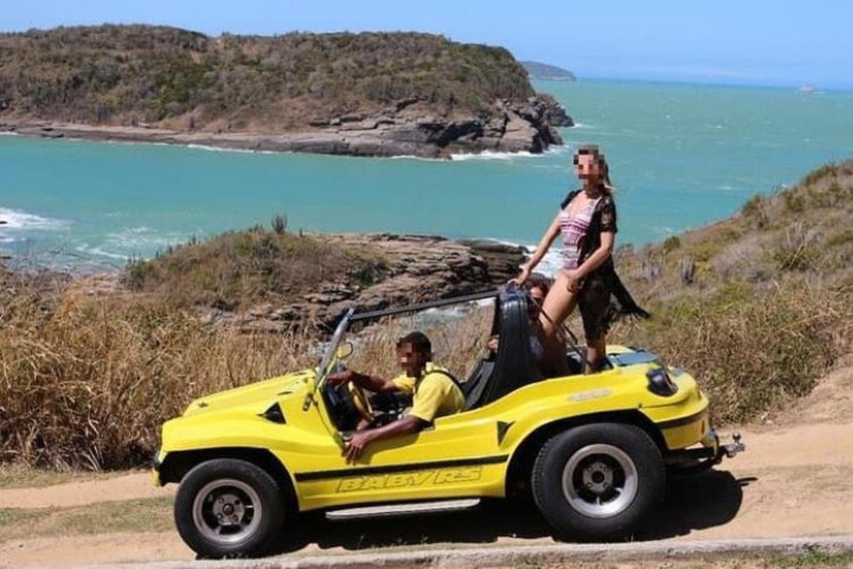 Un hombre y una mujer de pie encima de un coche amarillo.