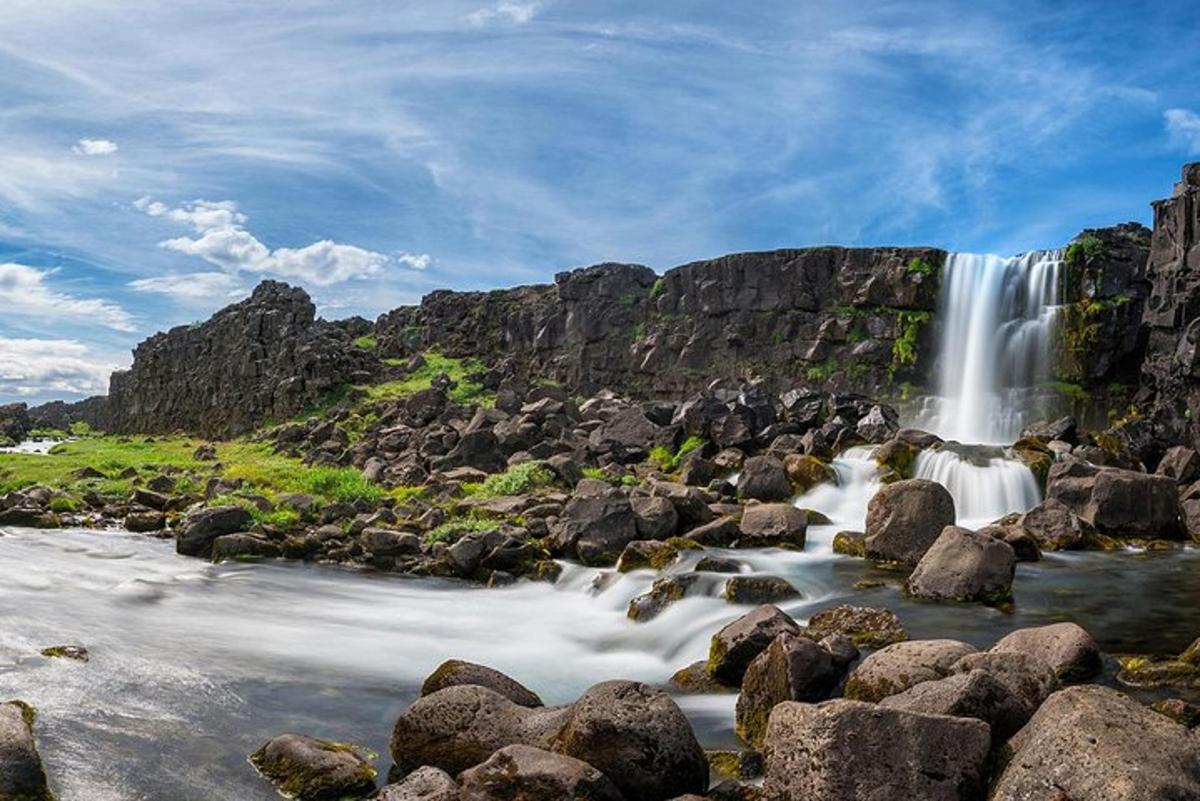 una cascada a la vora d'un riu amb roques