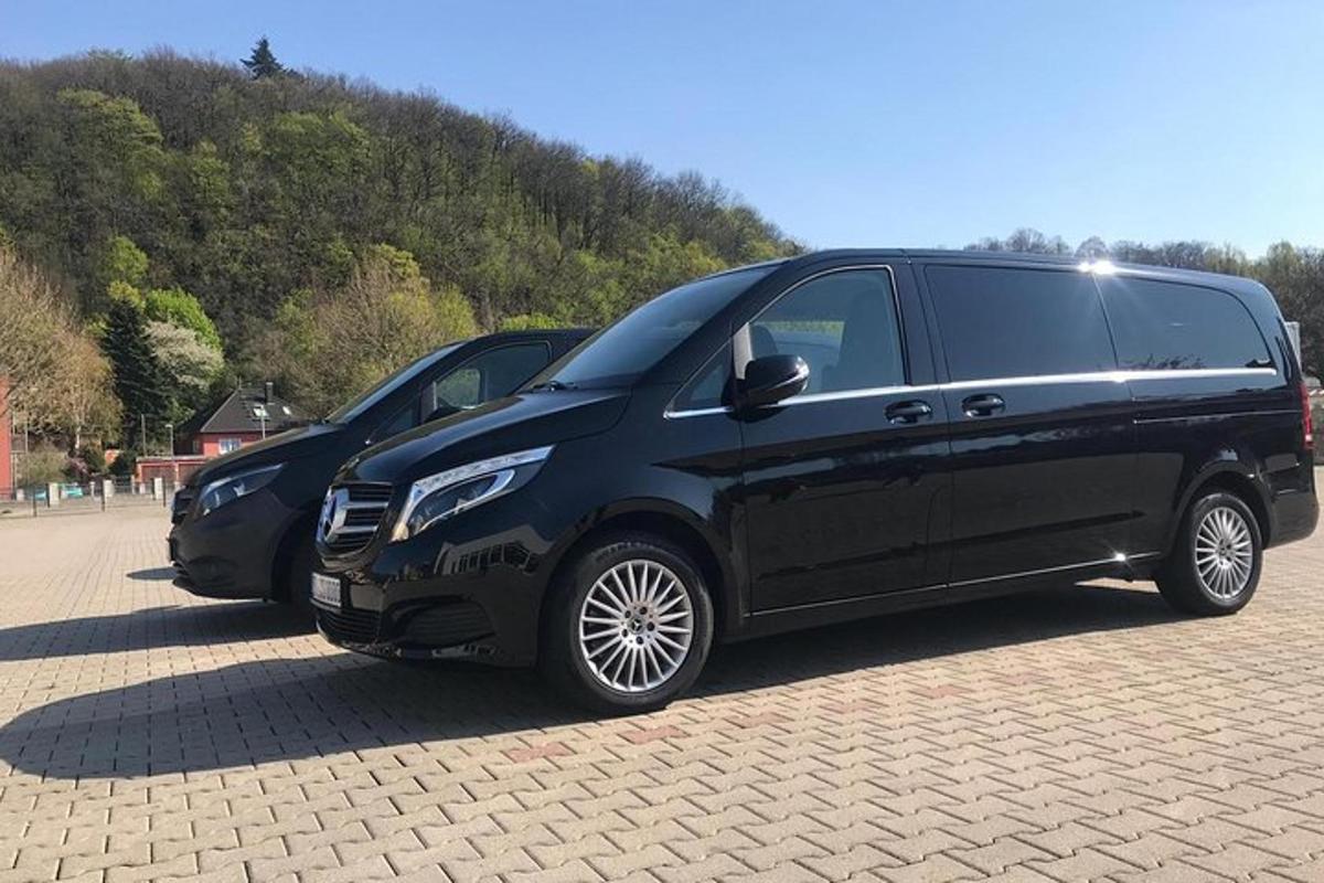 duas vans pretas estacionadas em um estacionamento