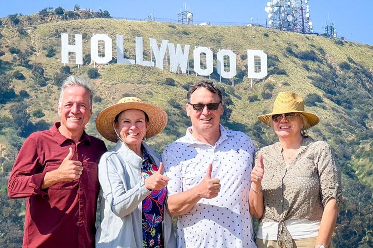grupp inimesi seisab Hollywoodi sildi ees