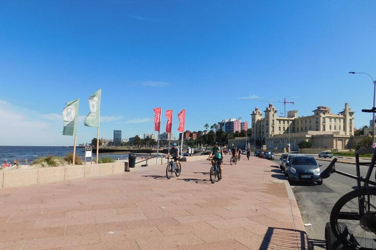 skupina lidí jedoucích na kolech po chodníku poblíž pláže