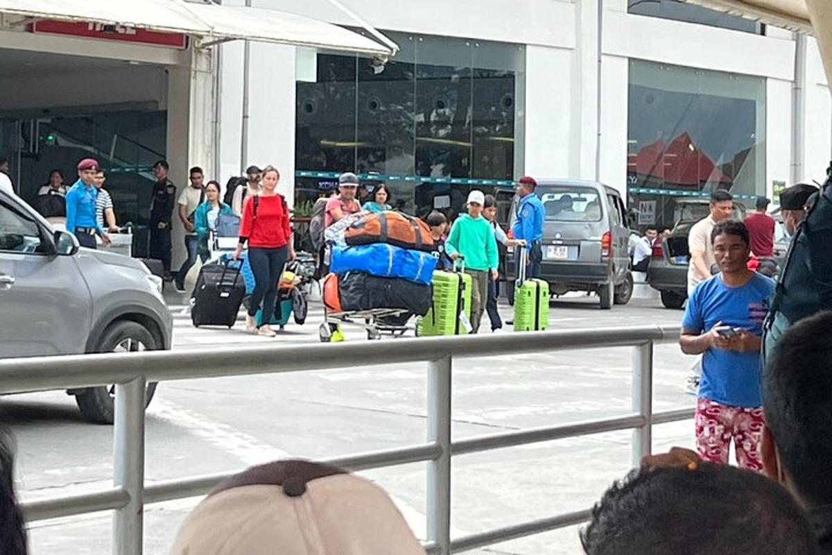 a group of people standing in a parking lot with luggage