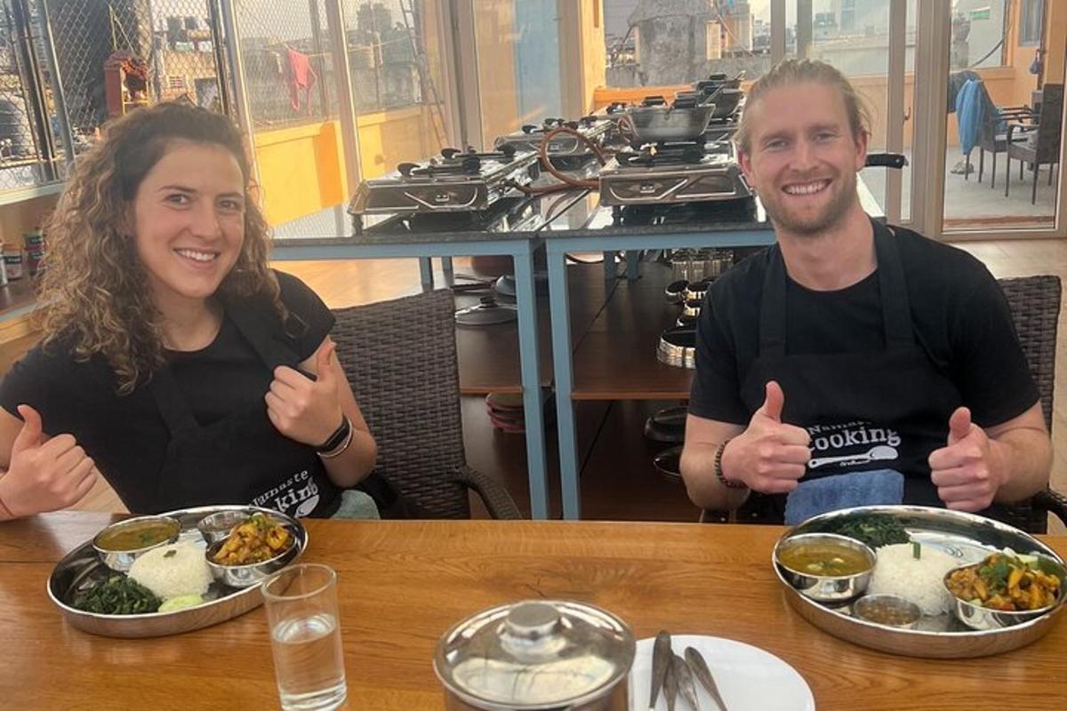 a man and woman sitting at a table with plates of food