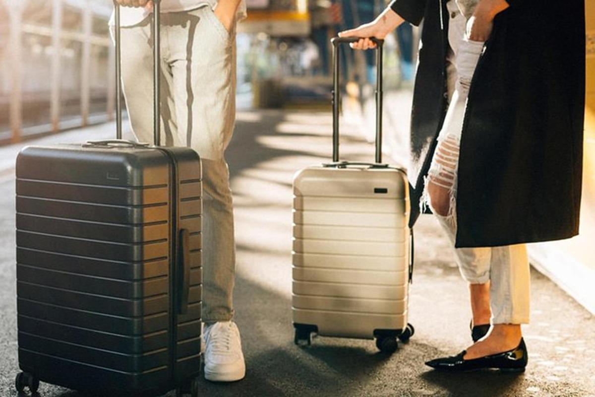 divi cilvēki stāv uz ielas ar savu bagāžu