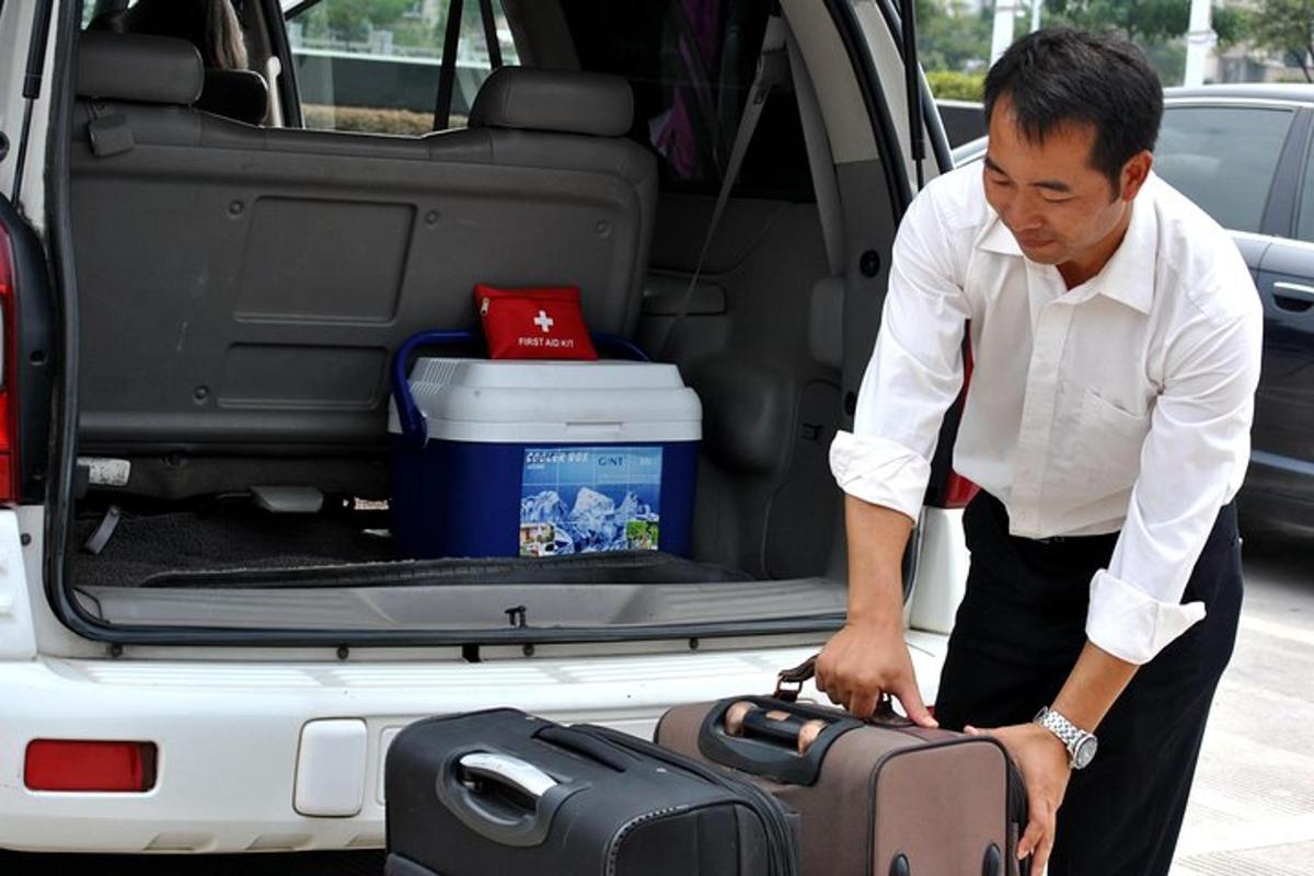 a man loading a suitcase into the back of a van