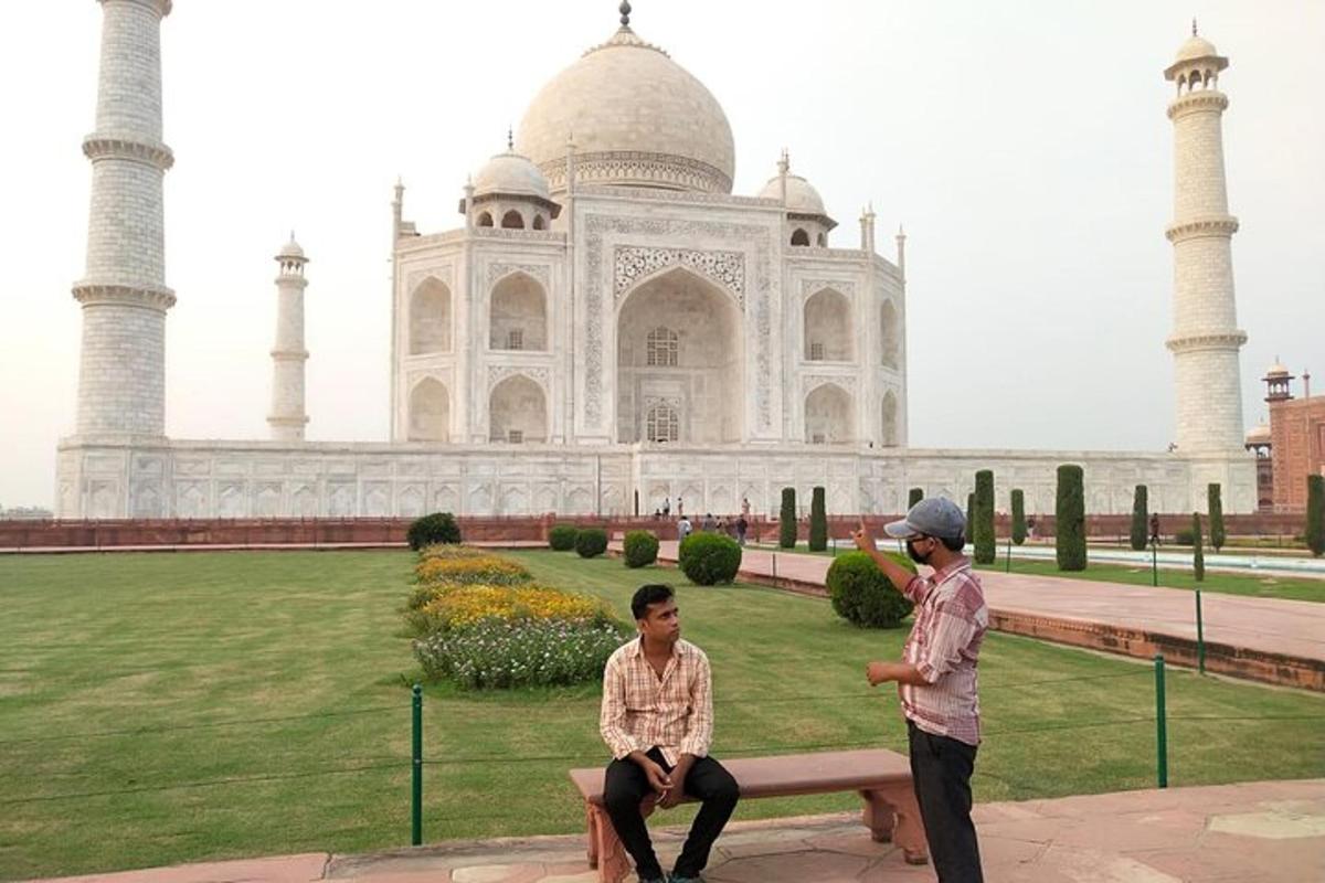 two men sitting on a bench in front of a building