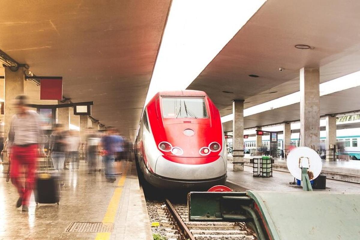 a red train is on the tracks at a train station