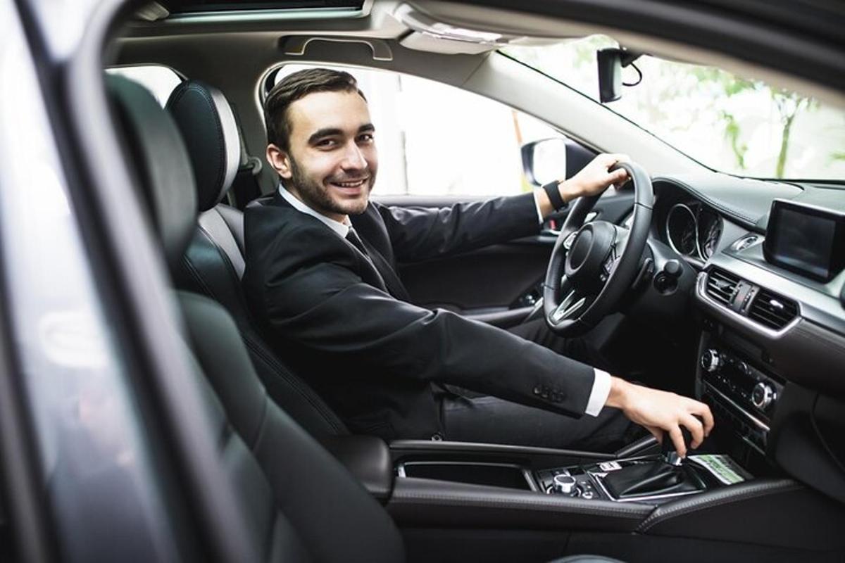 a man in a suit driving a car