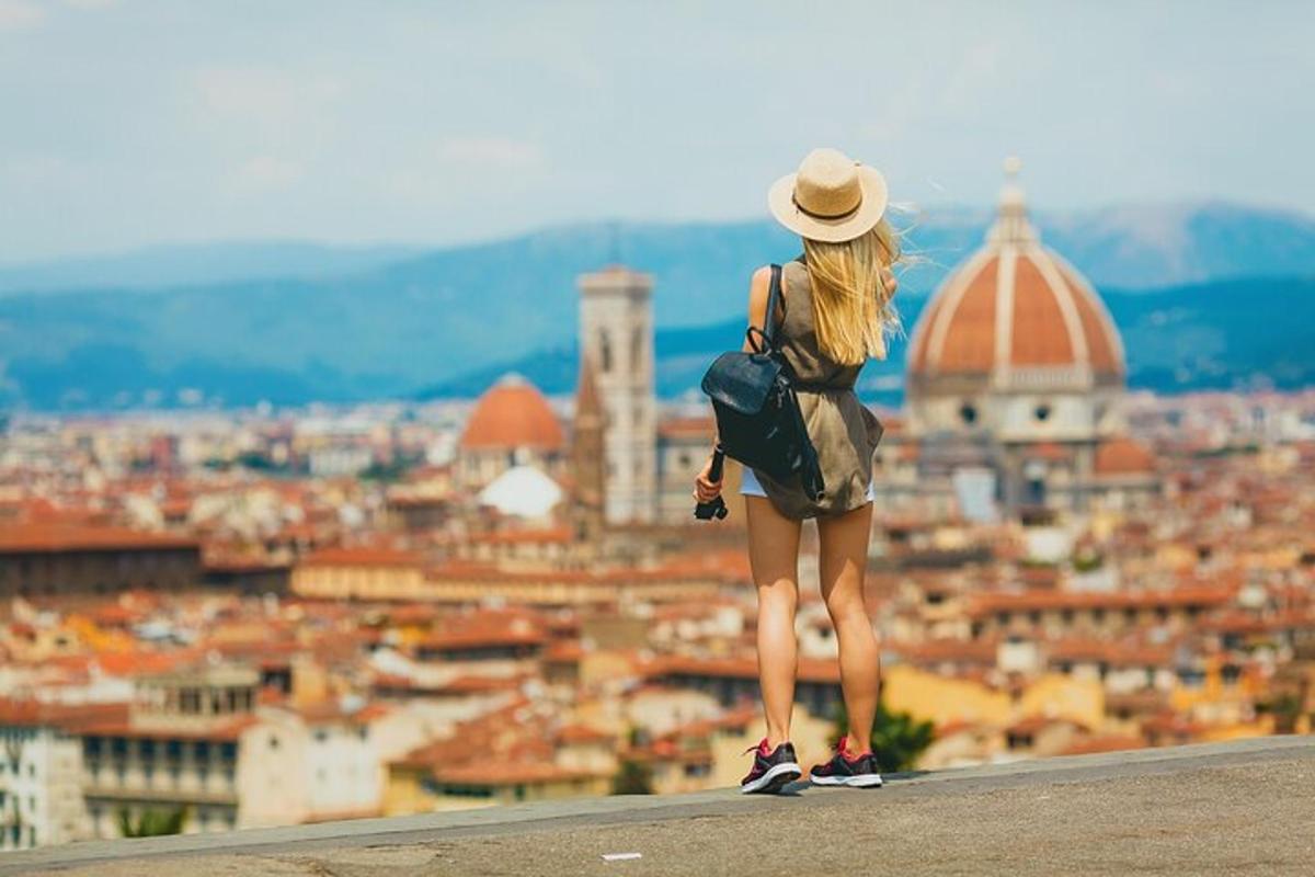 a woman standing on a ledge looking at a city