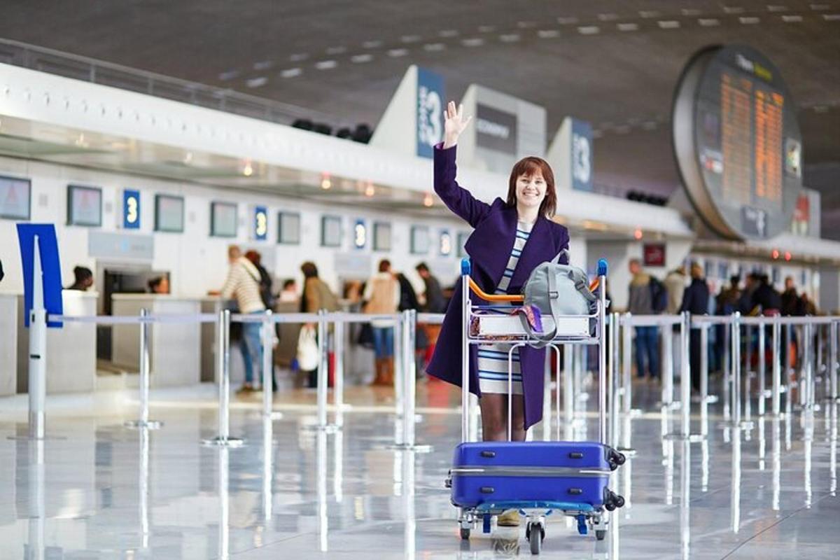 eine Frau, die mit erhobener Hand in einem Flughafen steht