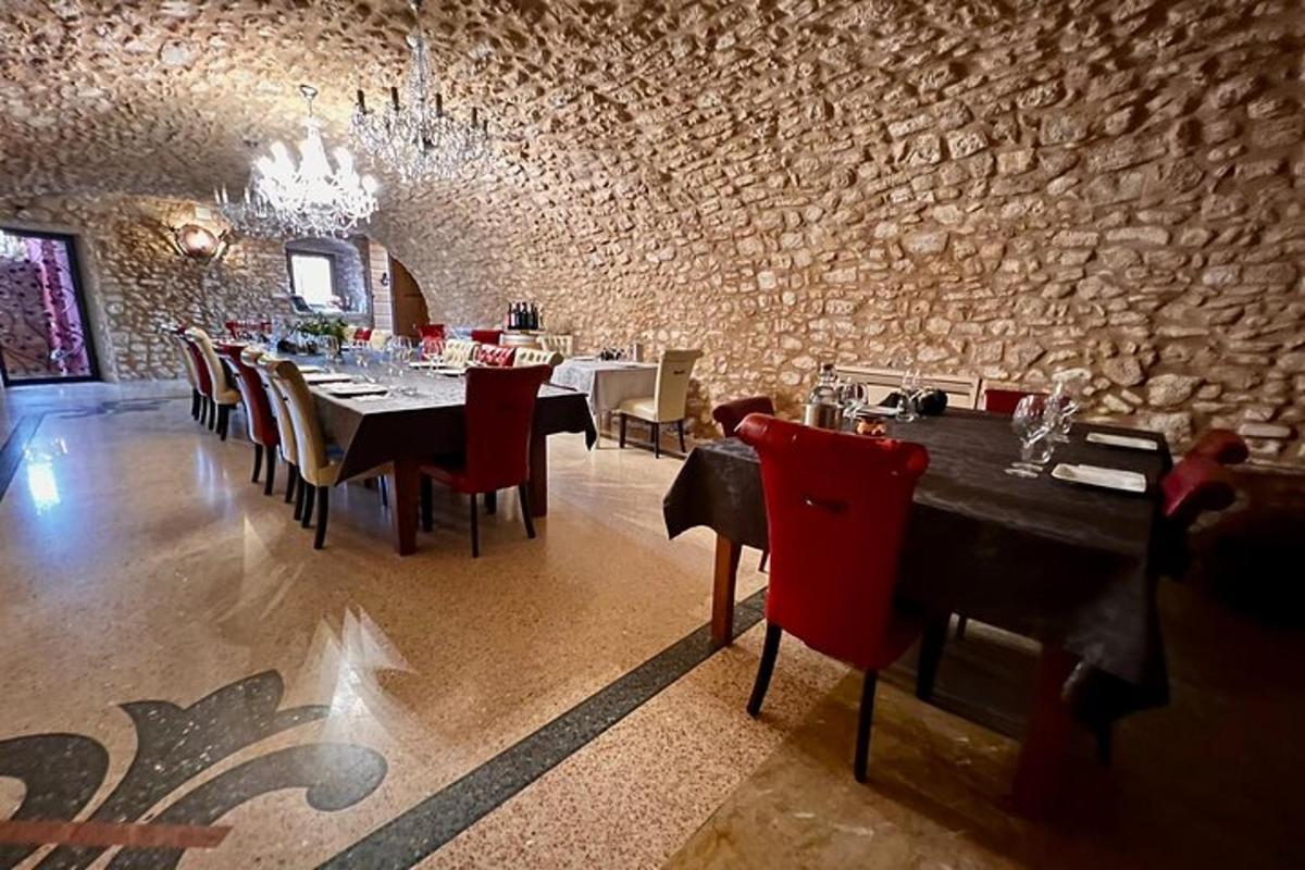 una sala da pranzo con tavoli e sedie e un muro di pietra