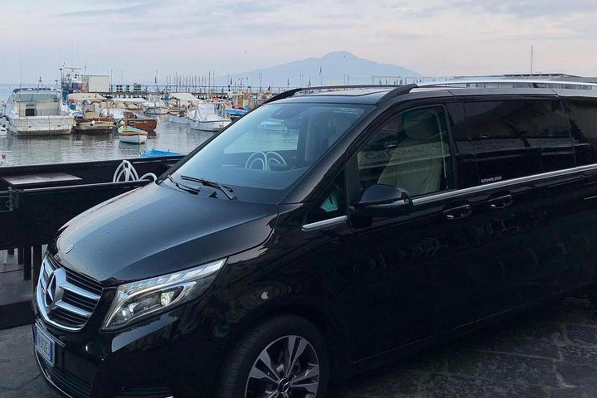 un SUV nero parcheggiato accanto a un porto con barche