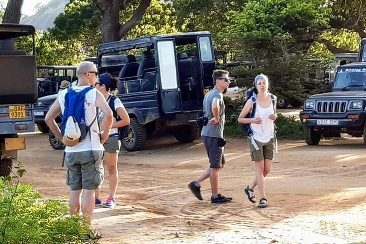 skupina lidí jdoucích před džípem
