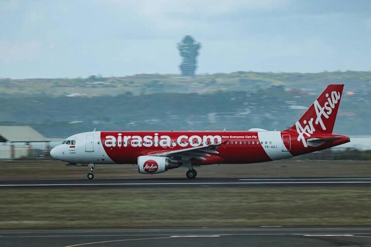 Un avión rojo y blanco está en una pista