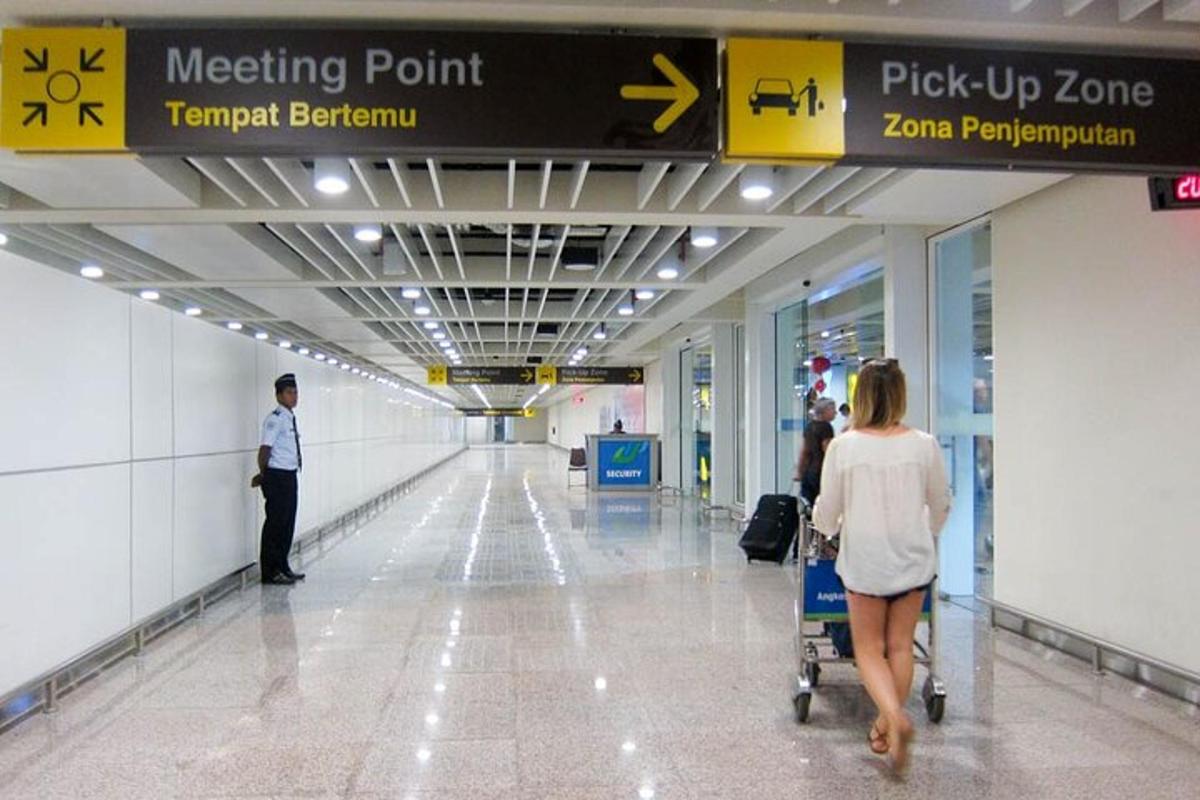 Μια γυναίκα σπρώχνει ένα καρότσι αποσκευών σε ένα αεροδρόμιο