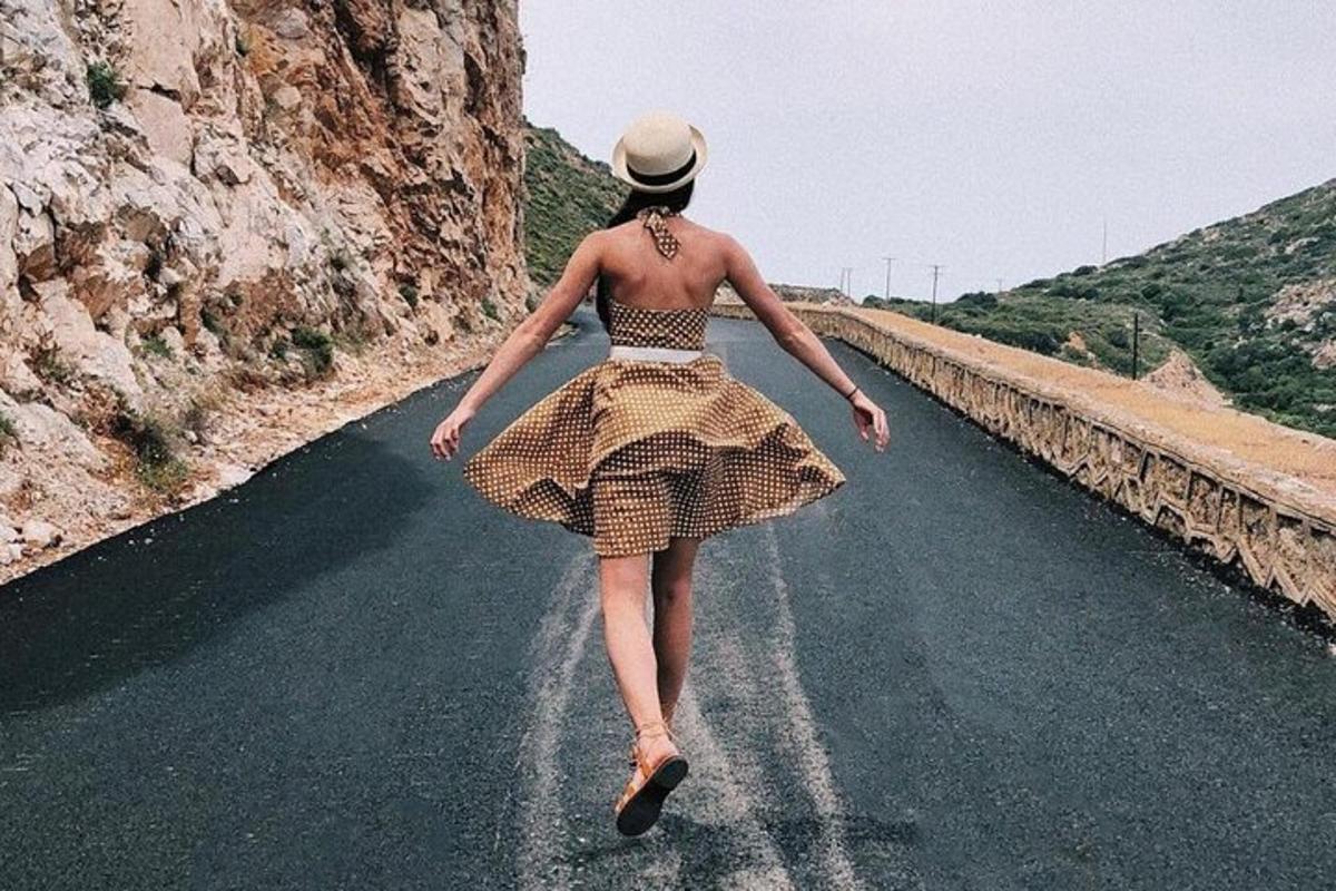 una donna in abito che cammina lungo una strada