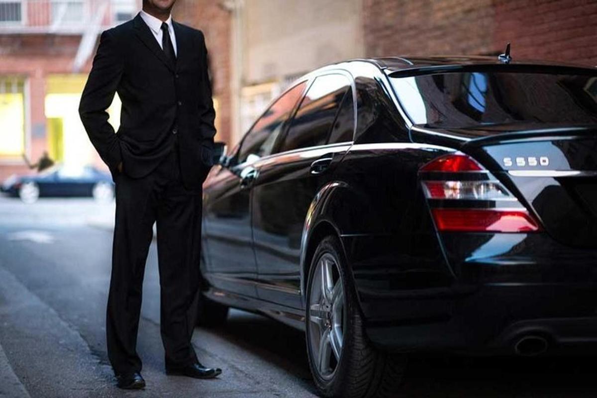 a man in a suit standing next to a car