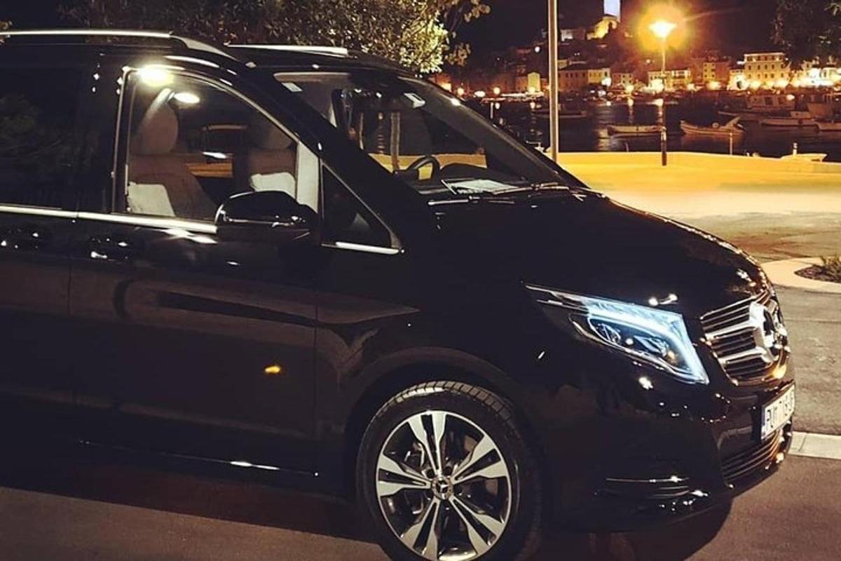 Un coche negro estacionado en un estacionamiento por la noche.