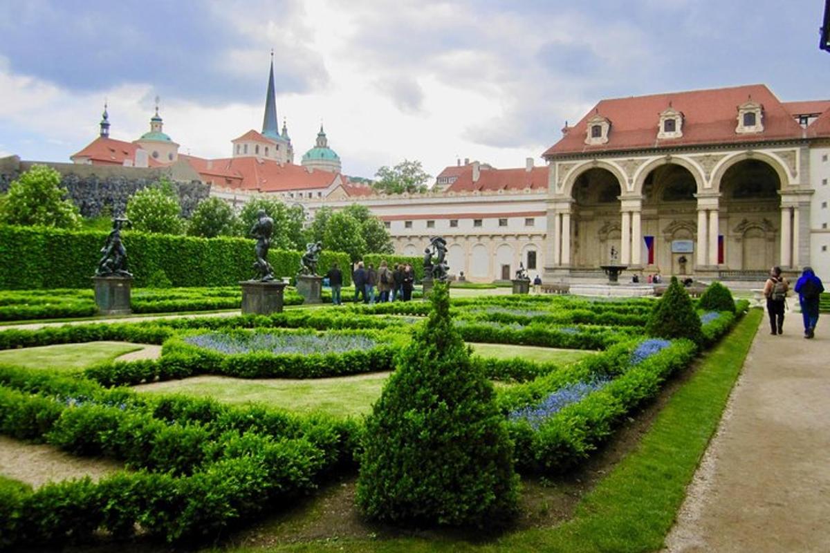 zahrada před budovou, kolem které se procházejí lidé