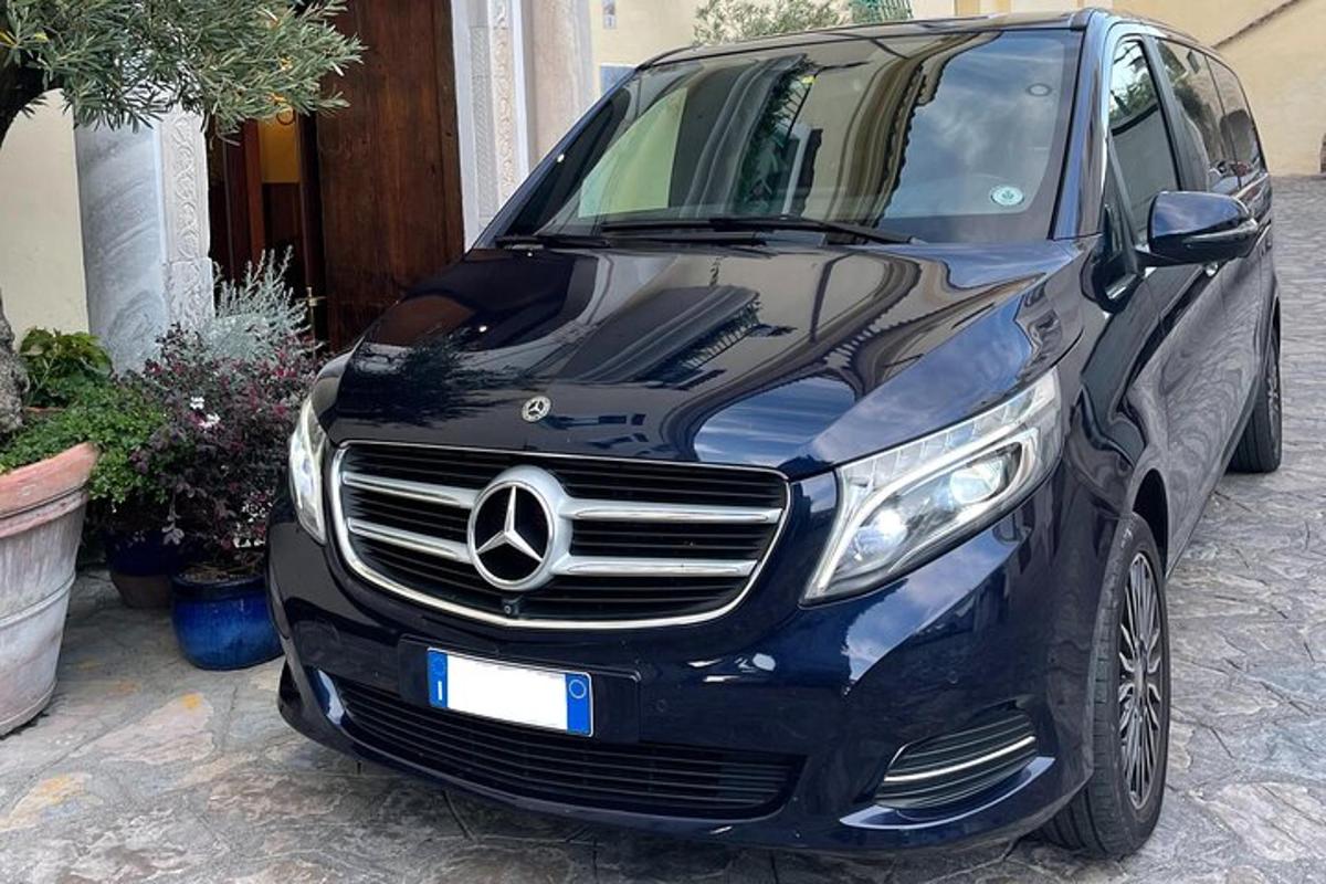 Černé auto Mercedes Benz zaparkované na příjezdové cestě