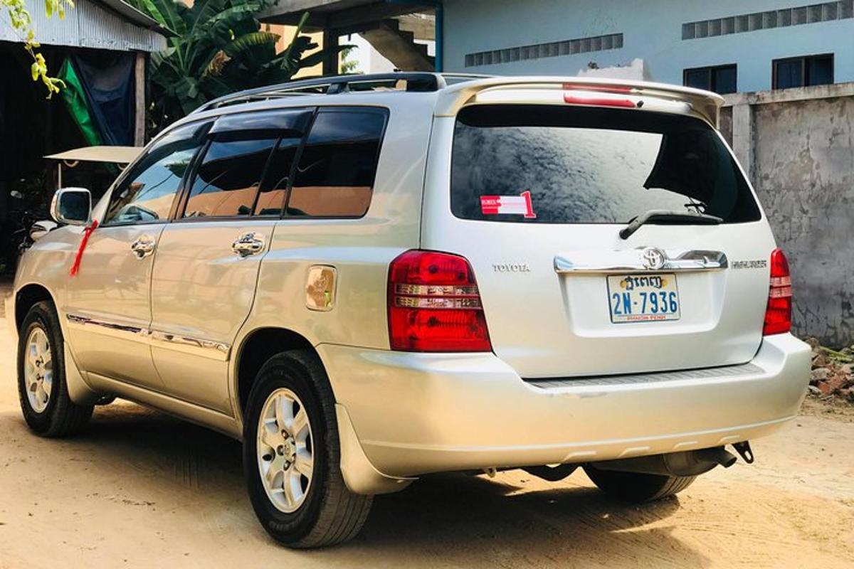 um SUV prateado estacionado em uma estrada de terra