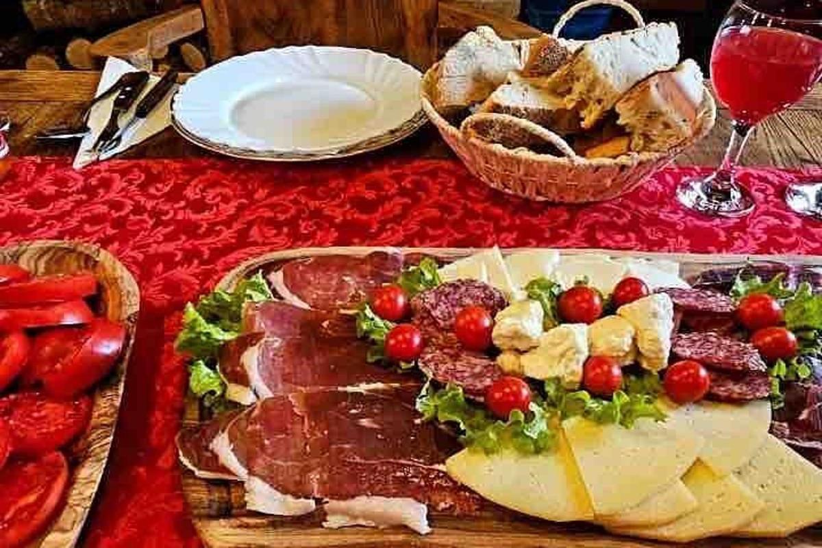 un tavolo con un vassoio di formaggio, carne e pane