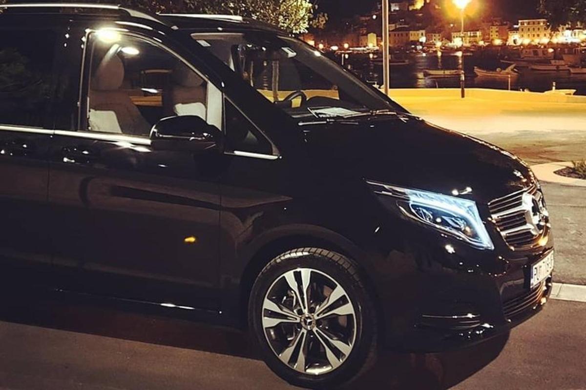 Un coche negro estacionado en un estacionamiento por la noche.