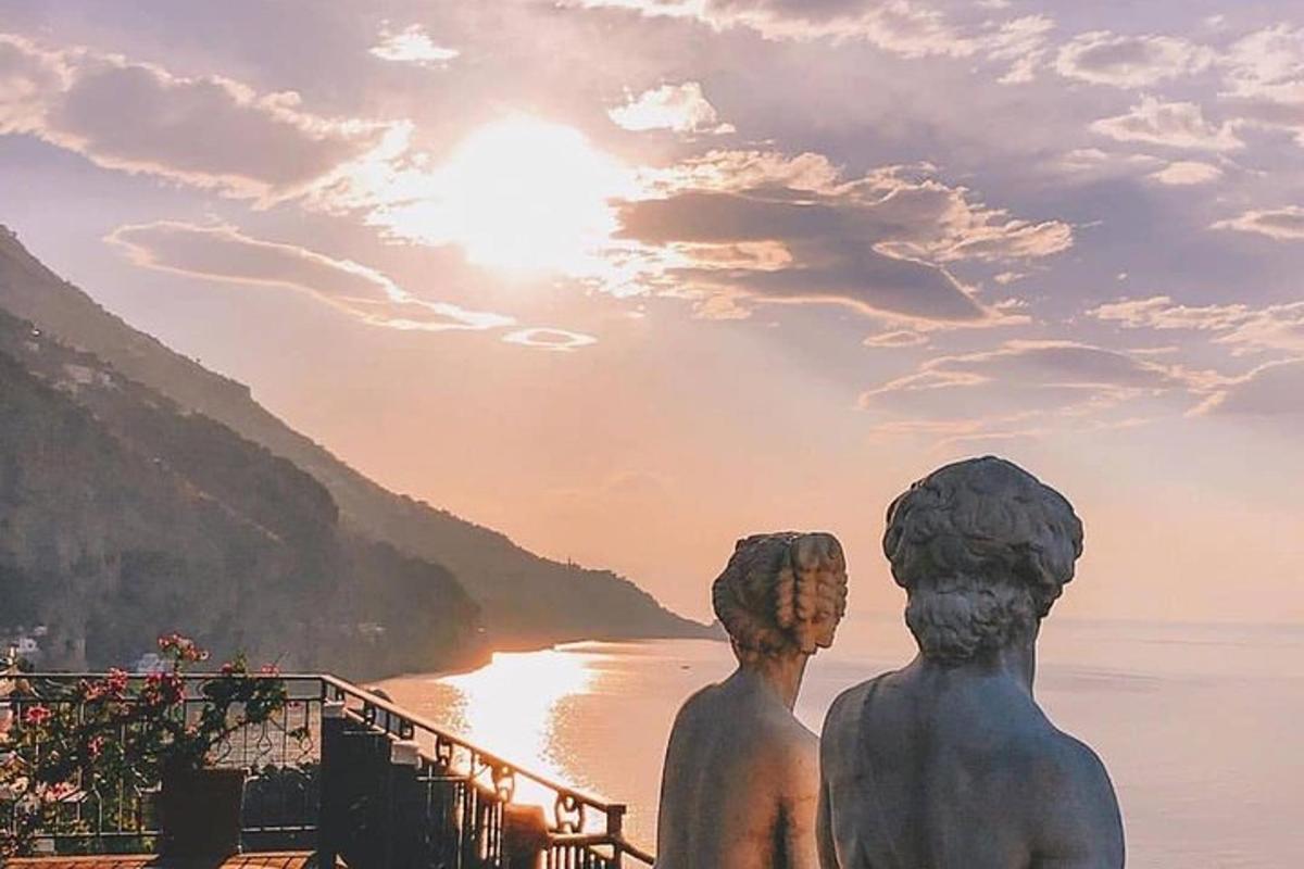 Una estatua de dos personas mirando hacia un cuerpo de agua.