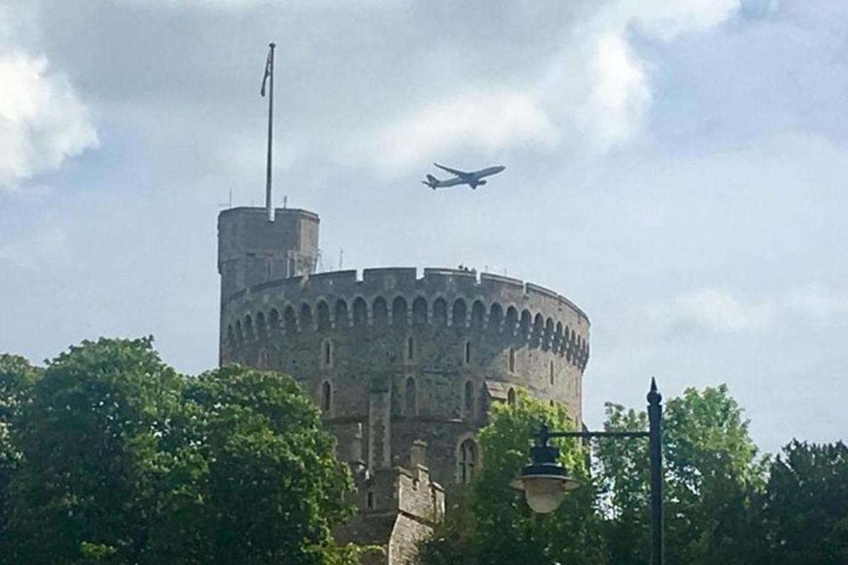 an airplane flying over a building with a flag