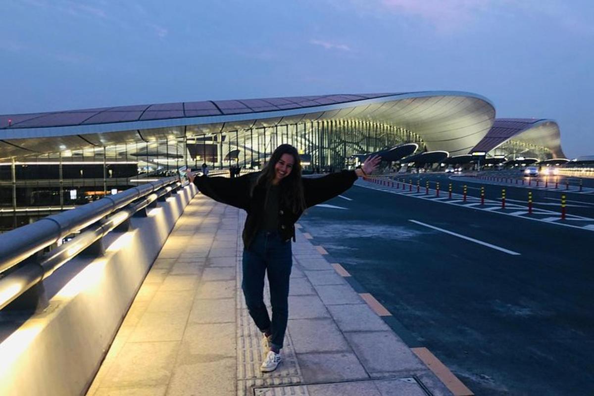 a woman is standing on a bridge with a skateboard