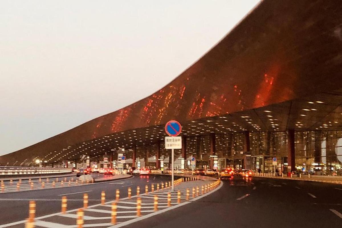 a fire is burning in a building with cars on a road
