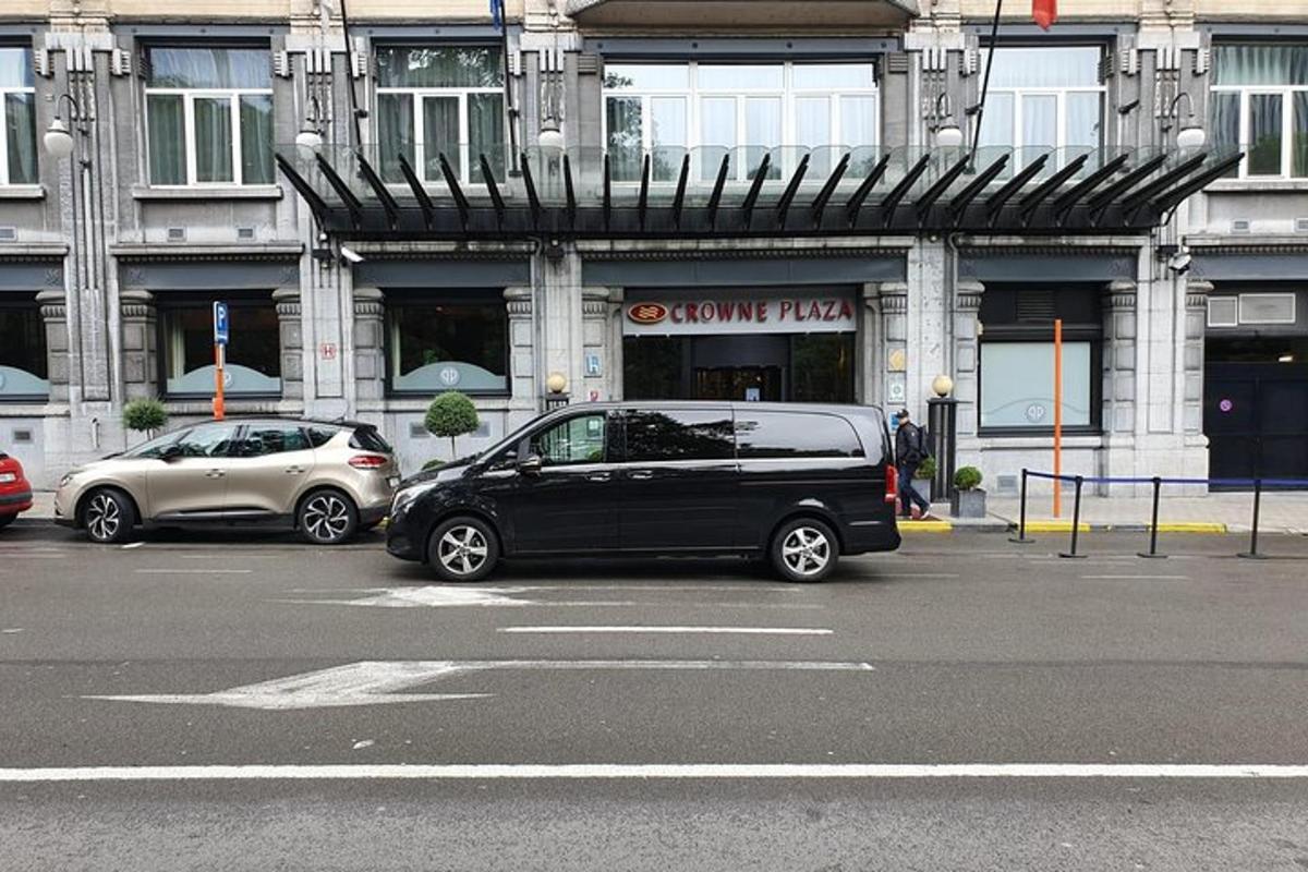 Dos coches estacionados en un estacionamiento frente a un edificio.